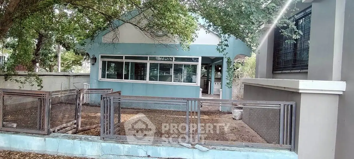 Charming blue house with spacious front yard and mature trees