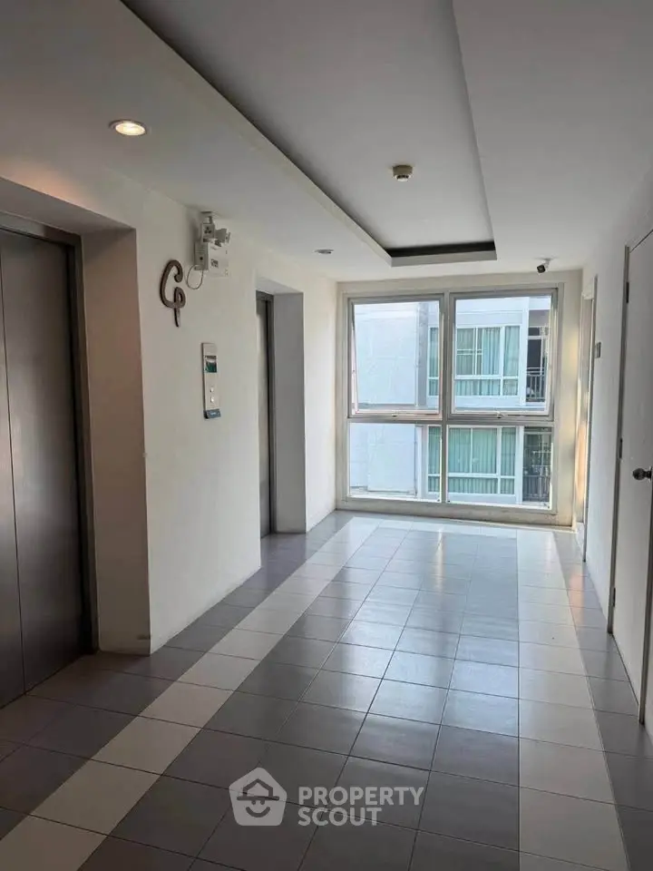 Modern apartment corridor with elevator and large window view