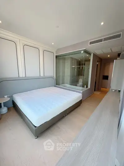 Modern bedroom with glass wall bathroom and sleek design