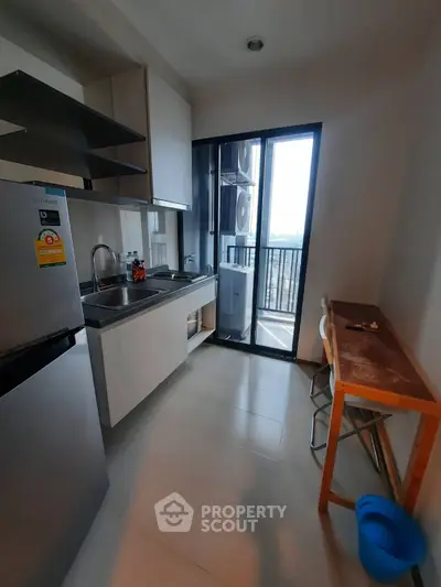 Modern kitchen with sleek appliances and balcony view, perfect for urban living.
