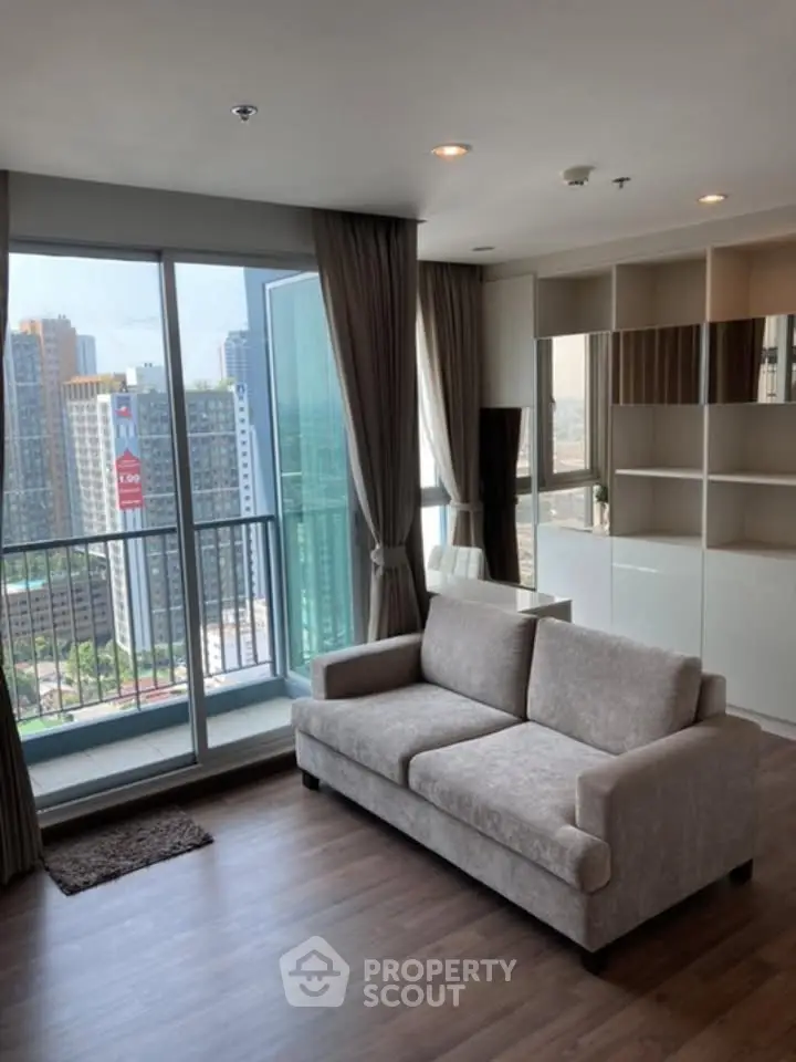 Modern living room with city view and balcony access in high-rise apartment