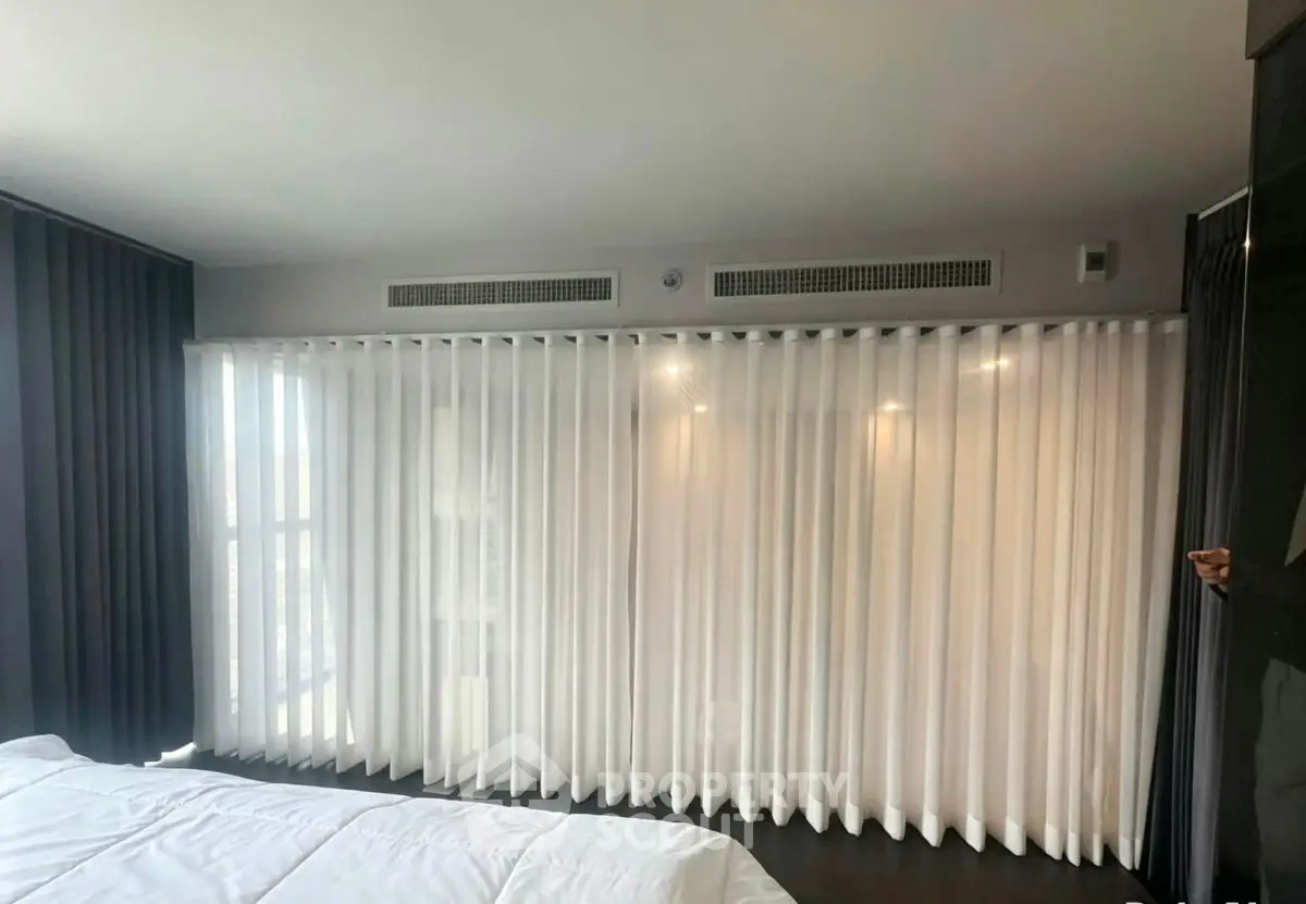 Modern bedroom with floor-to-ceiling windows and elegant curtains