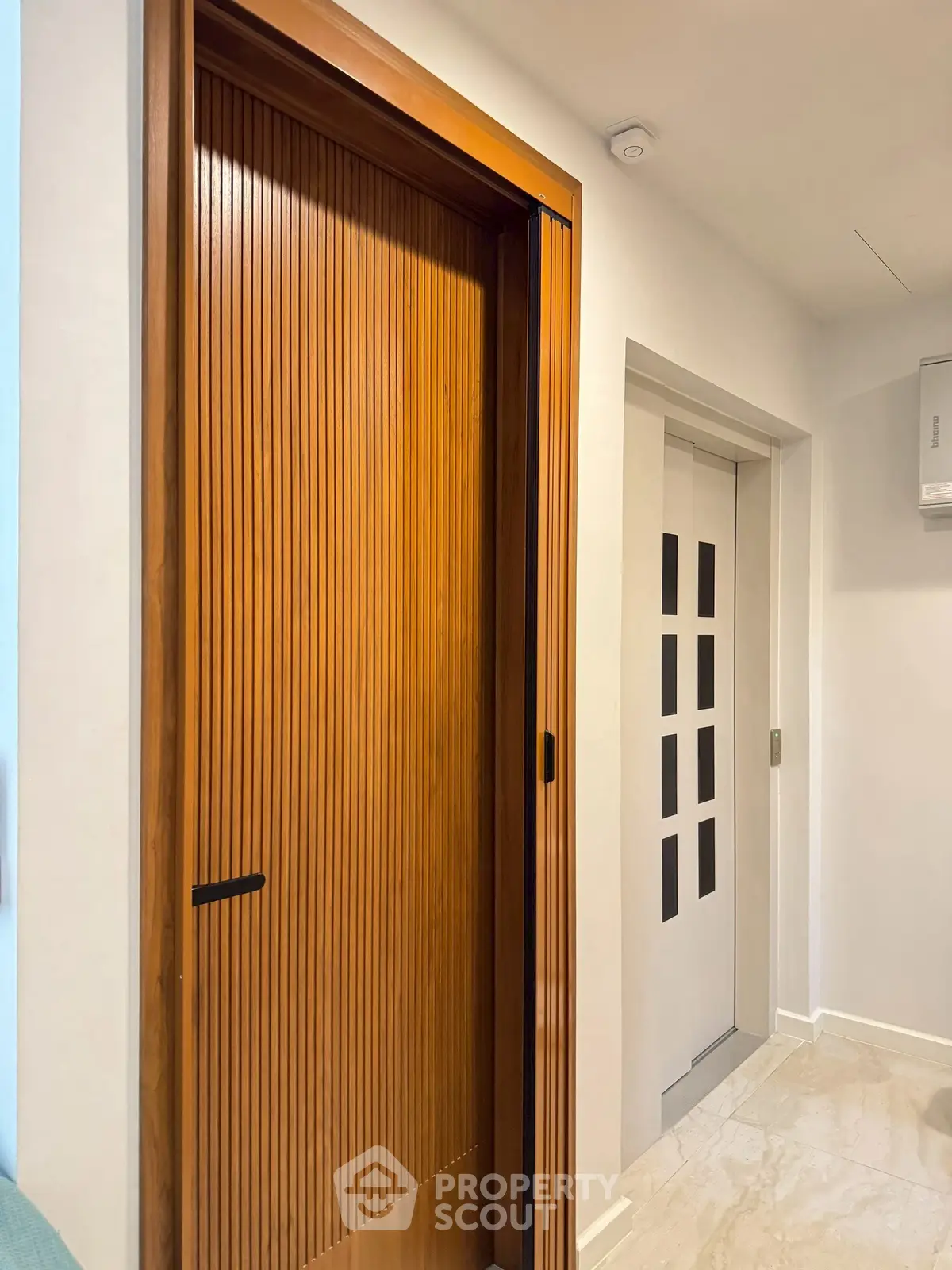 Modern interior with wooden sliding door and sleek elevator entrance