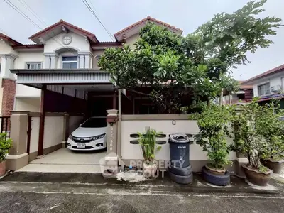 Charming townhouse with carport and lush garden in a serene neighborhood.