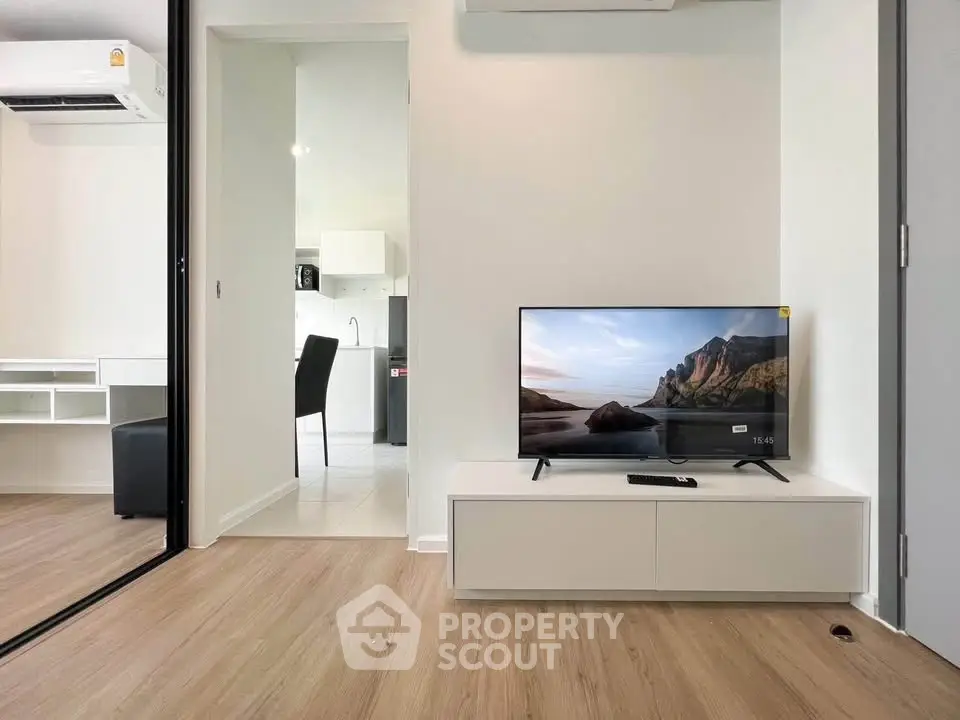 Modern living room with sleek TV setup and open kitchen view