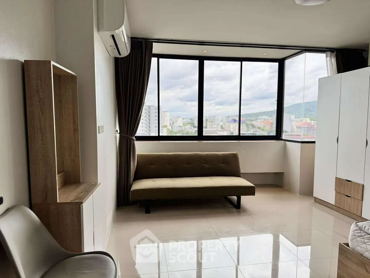 Spacious living room with large windows offering stunning city views, modern furniture, and sleek flooring.