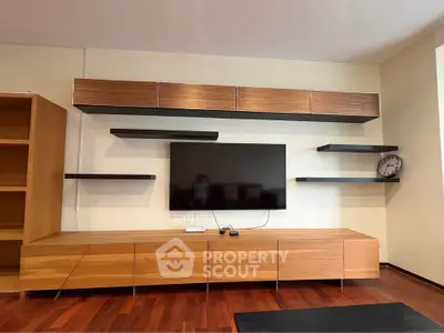 Modern living room with sleek wooden entertainment unit and wall-mounted TV