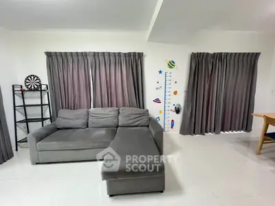 Spacious living room with modern gray sectional sofa and stylish decor, perfect for family gatherings.