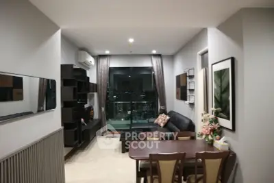 Modern living room with city view, stylish decor, and cozy seating area.