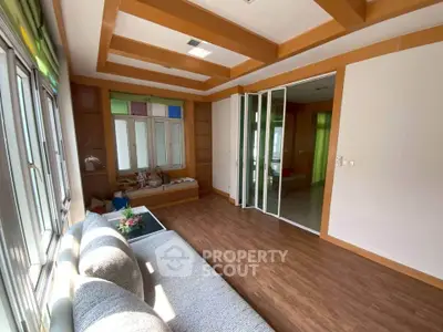 Spacious living room with wooden flooring and large windows, perfect for natural light.