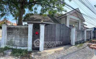 Charming suburban house with gated entrance and lush greenery