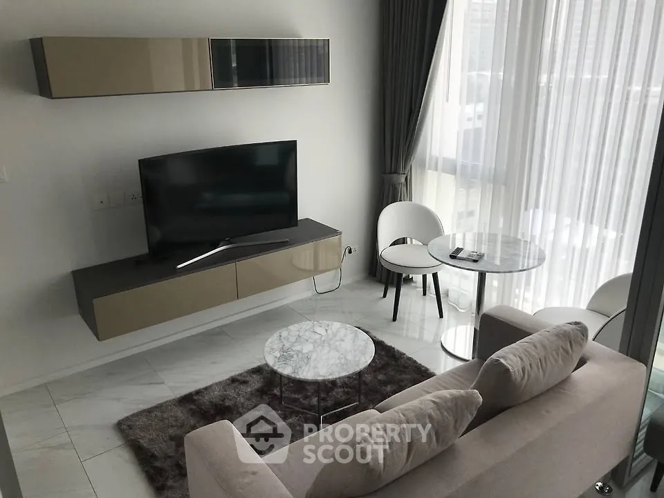 Modern living room with sleek furniture and large windows offering natural light.