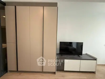 Modern apartment interior with sleek wardrobe and TV unit, showcasing minimalist design and ample storage.