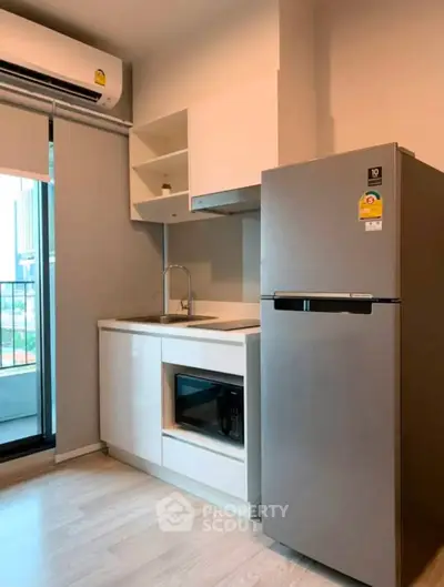 Modern kitchen with sleek appliances and balcony view in urban apartment