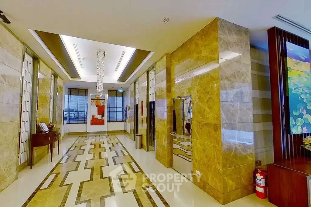 Luxurious building entrance with elegant marble flooring and modern lighting fixtures.