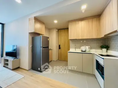 Modern kitchen with sleek appliances and stylish cabinetry in a contemporary apartment.