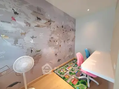 Charming study room with world map mural and colorful chairs, perfect for kids' learning and creativity.