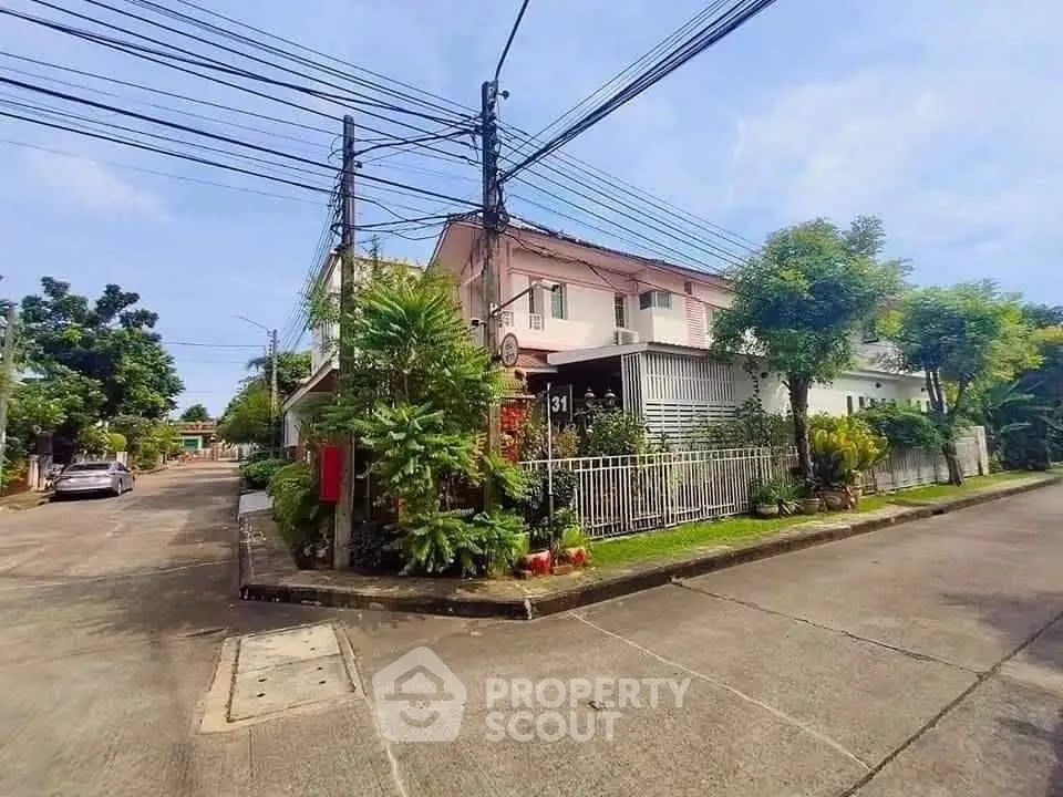 Charming corner house with lush greenery and modern design in a serene neighborhood.