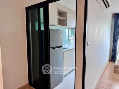 Modern apartment with sleek kitchen featuring stainless steel fridge and open layout design.