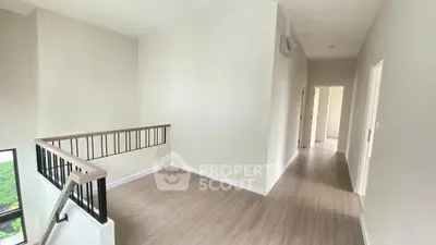Spacious and bright hallway with modern wooden flooring and elegant railing.
