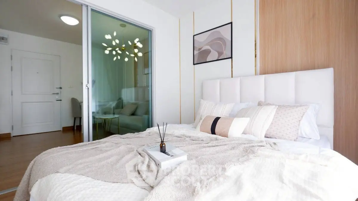 Modern bedroom with cozy decor and stylish wall art in a bright apartment.