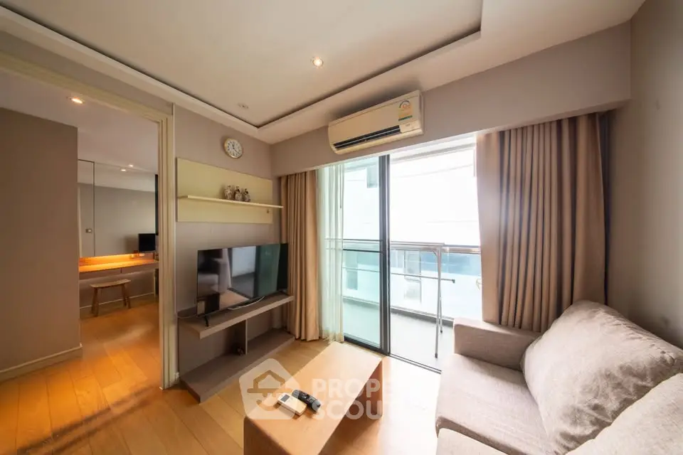 Modern living room with balcony access, featuring cozy sofa and wall-mounted TV in a bright, airy space.