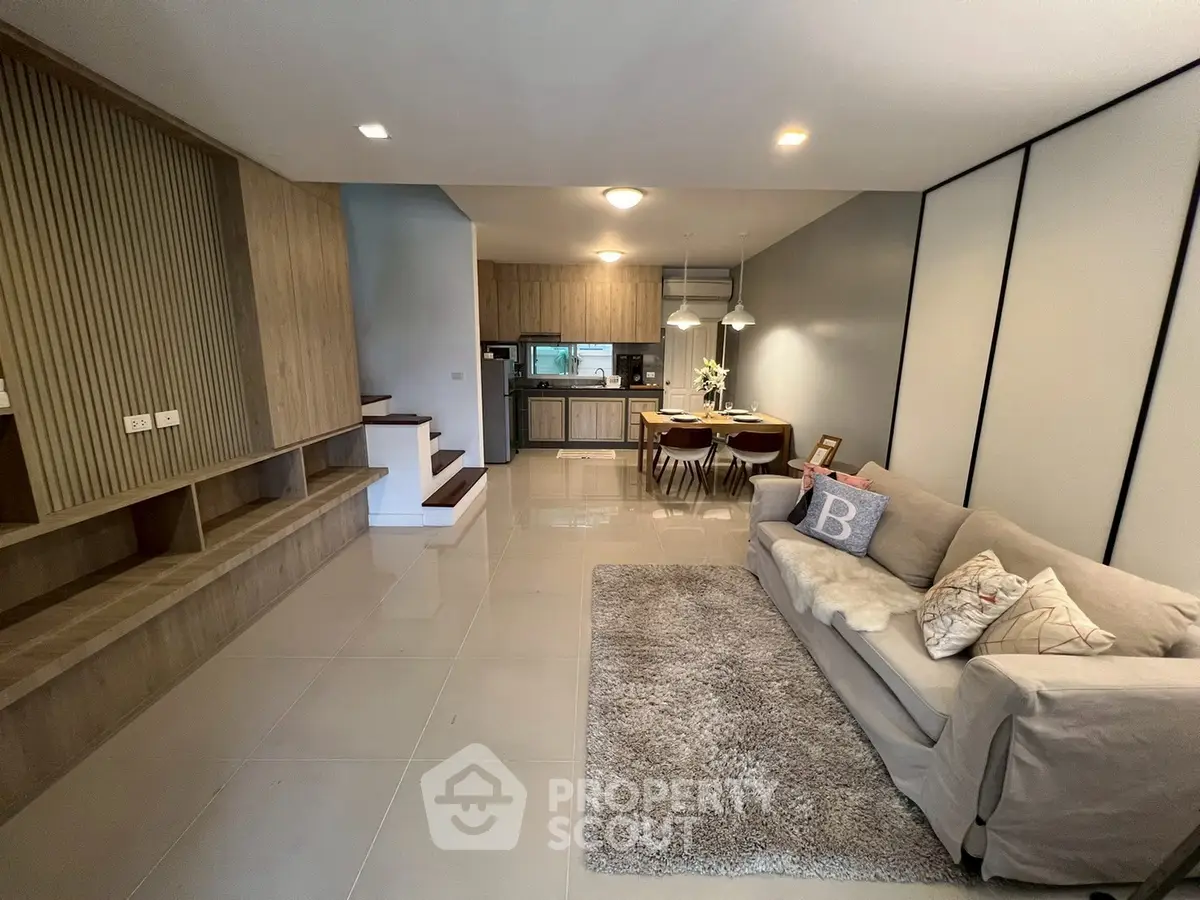 Modern open-plan living room with cozy sofa and stylish kitchen area