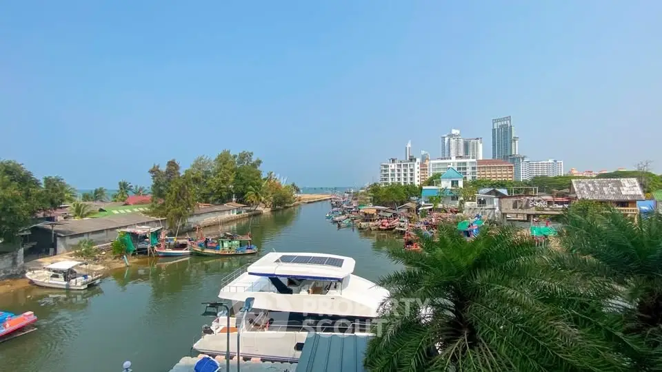 Scenic waterfront view with modern buildings and boats, ideal for luxury real estate investment.