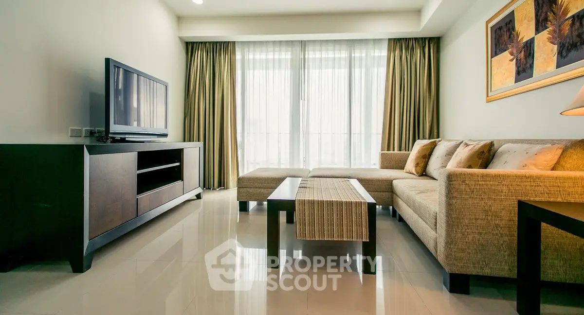 Spacious living room with modern furniture and large TV, perfect for relaxation.