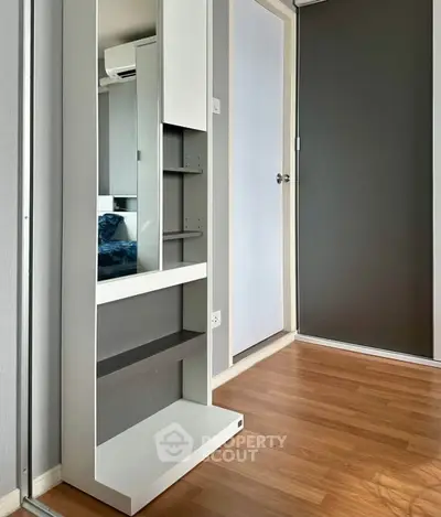Modern apartment interior with sleek wooden flooring and stylish storage solutions.