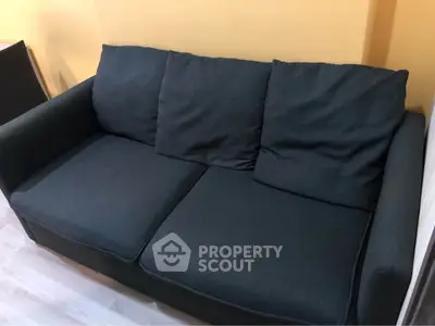 Cozy dark gray sofa in a modern living room with warm yellow walls.