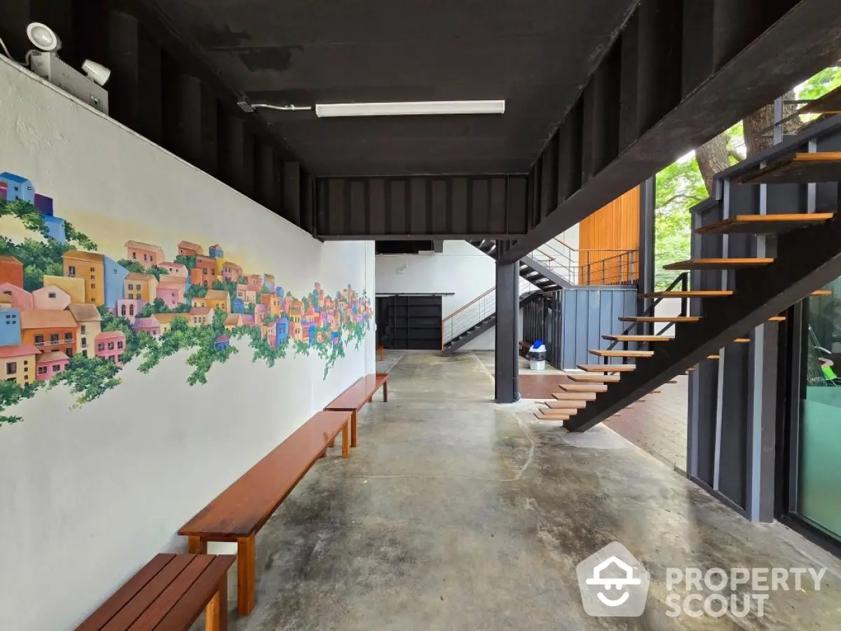 Modern industrial-style interior with open staircase and vibrant mural wall art