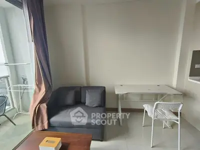 Cozy living room with modern furniture and balcony access in a stylish apartment.
