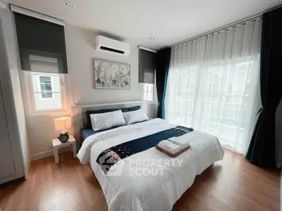 Modern bedroom with stylish decor and large windows for natural light