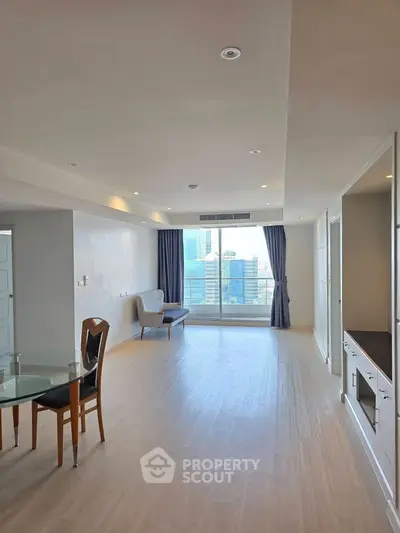 Spacious modern living room with large windows and city view, perfect for urban living.