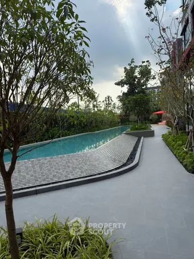 Luxurious outdoor pool area with lush greenery and modern design, perfect for relaxation and leisure.