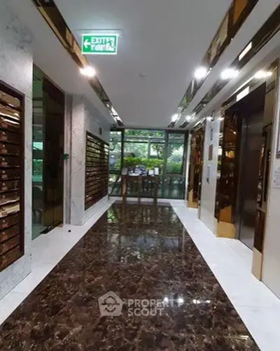 Luxurious building entrance with marble floors and modern mailboxes.