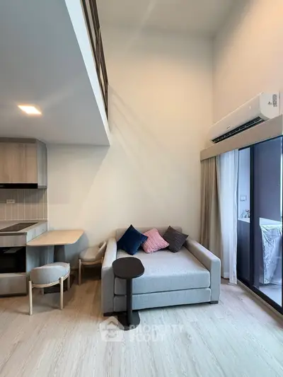 Modern loft apartment with cozy living area and open kitchen layout, featuring high ceilings and natural light.