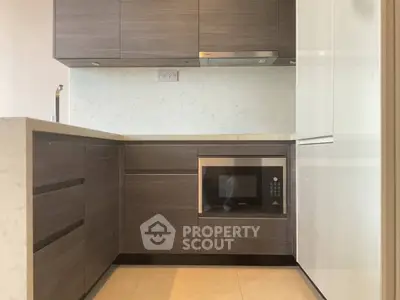 Modern kitchen with sleek cabinetry and built-in microwave, ideal for contemporary living.
