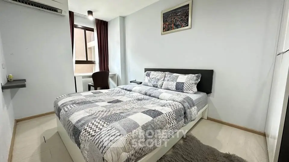 Cozy bedroom with modern decor and large window for natural light.