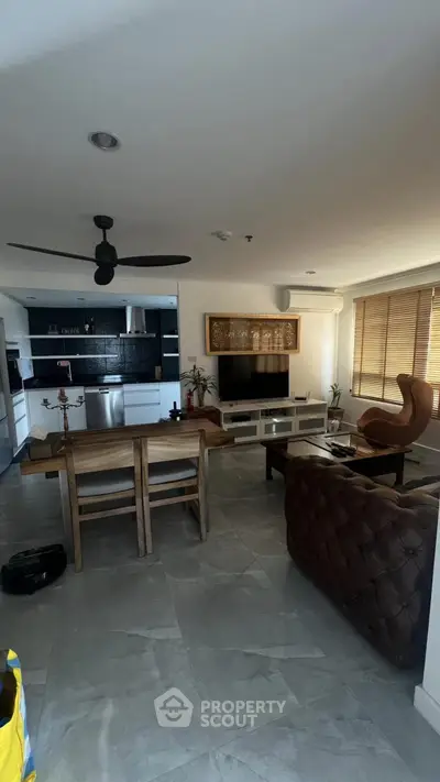 Spacious modern living room with open kitchen, featuring elegant furniture and sleek design.