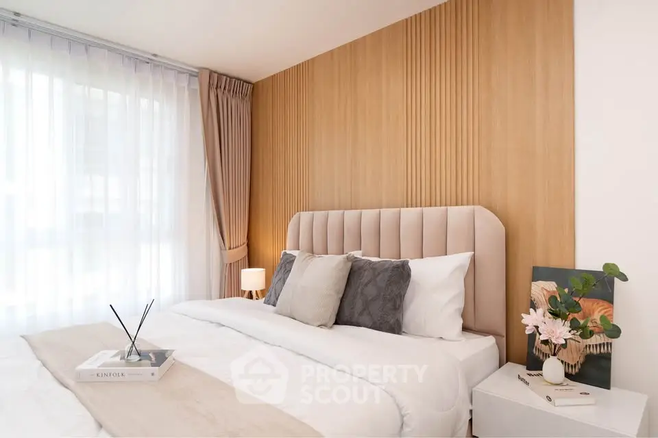 Elegant bedroom with plush headboard, soft lighting, and modern decor, perfect for relaxation and comfort.