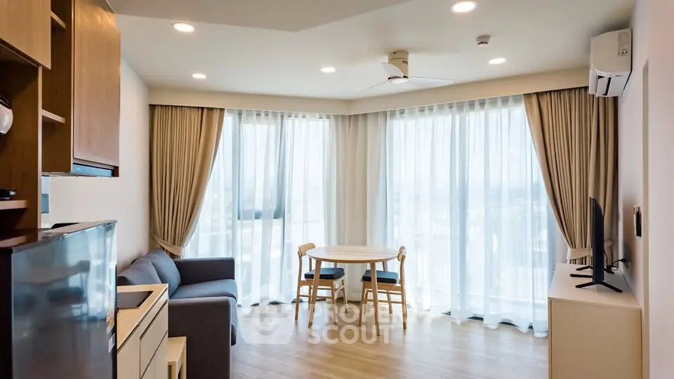 Modern living room with large windows and elegant furnishings in a bright apartment.