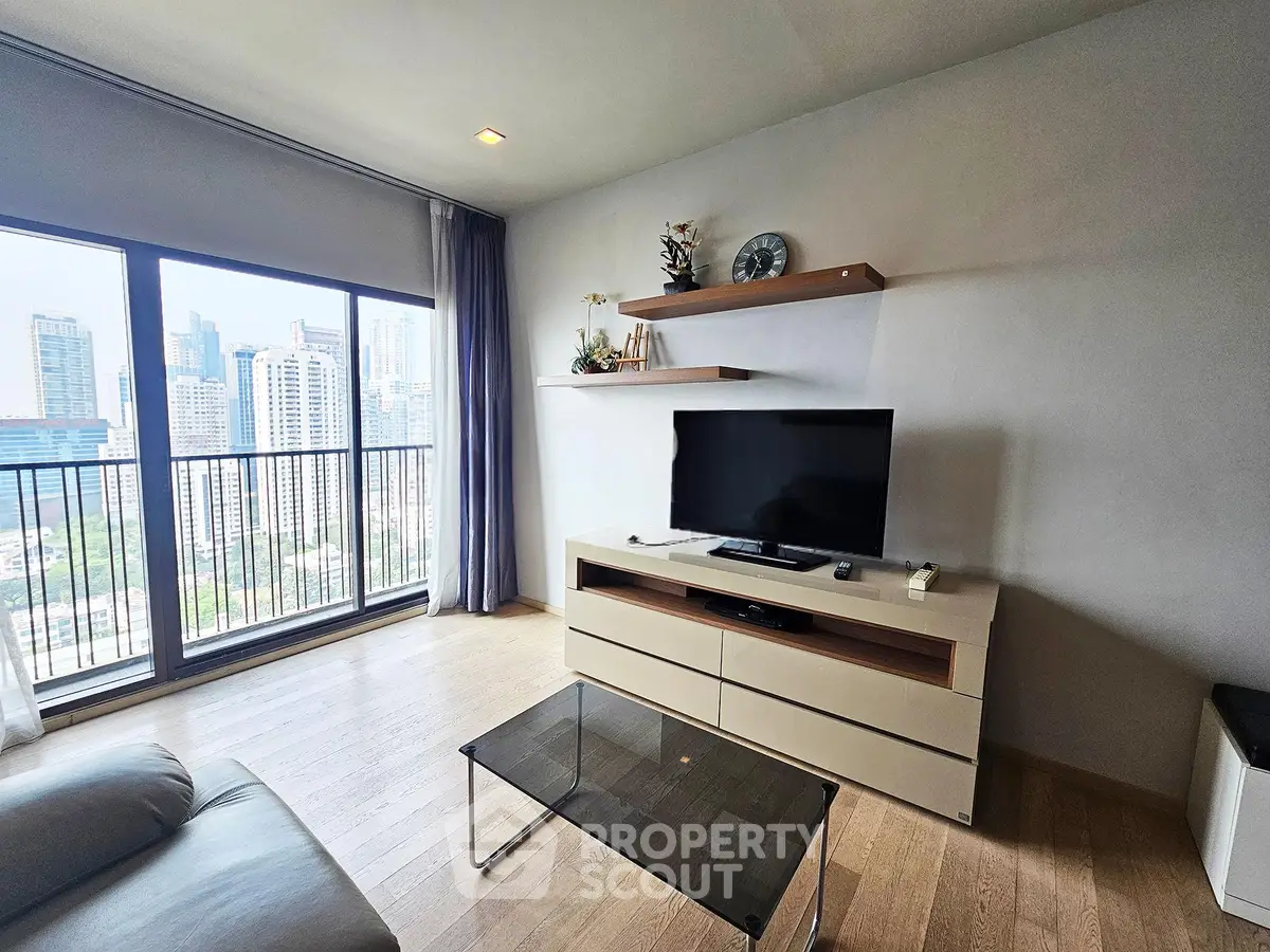 Modern living room with city view, featuring sleek furniture and large windows for natural light.