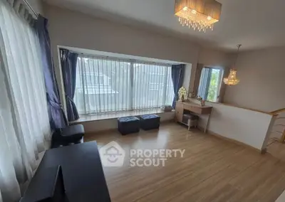 Spacious living room with large windows and elegant lighting, perfect for relaxation and entertaining.