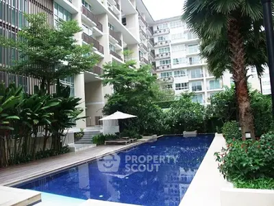 Luxurious condominium with a stunning outdoor pool and lush greenery.