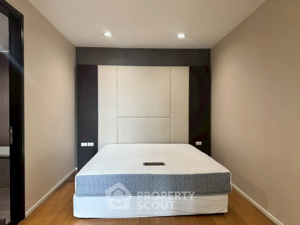 Spacious bedroom with modern design and elegant lighting, featuring a comfortable bed and stylish decor.