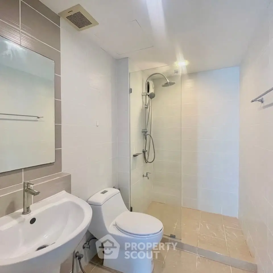 Modern bathroom with glass shower and sleek fixtures in a contemporary home.