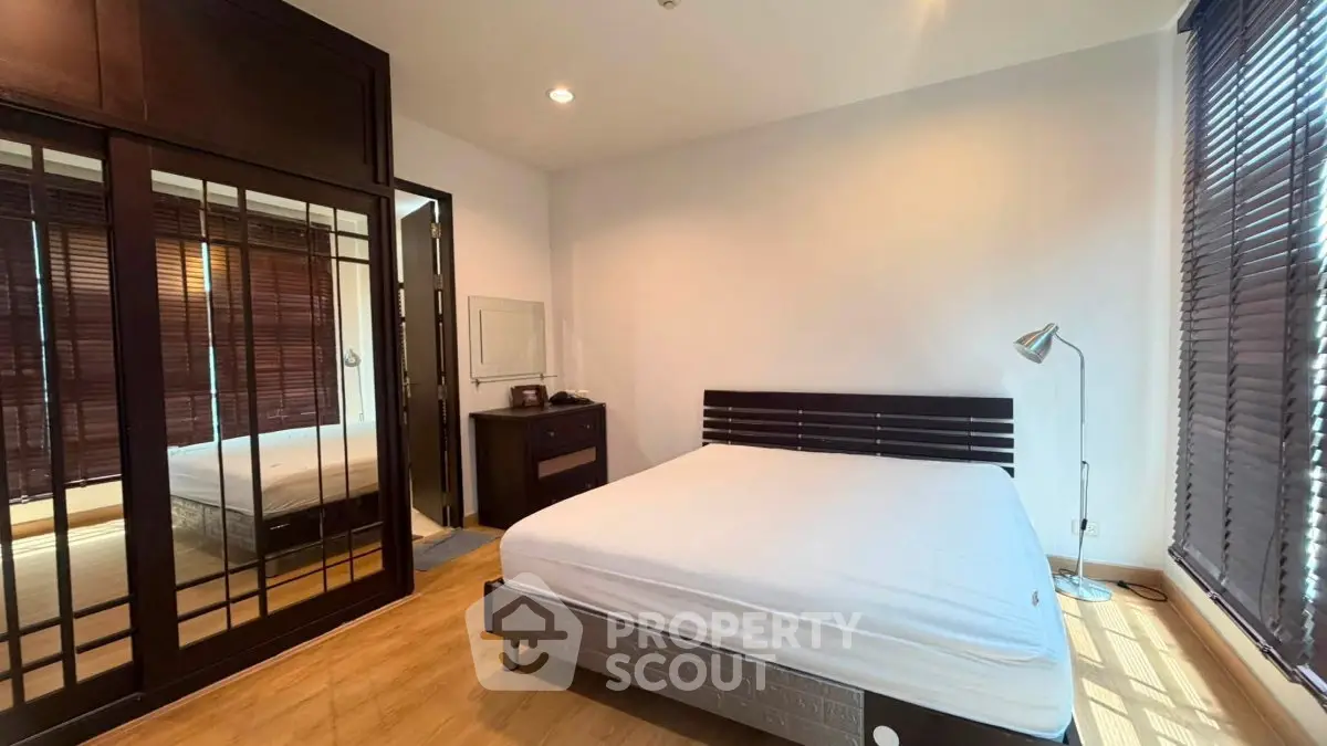 Spacious bedroom with large windows and modern furnishings, perfect for natural light lovers.