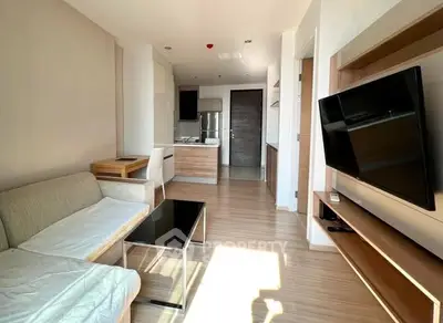 Modern living room with open kitchen and sleek furniture in bright apartment.